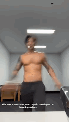 a shirtless man is jumping a rope in a room .