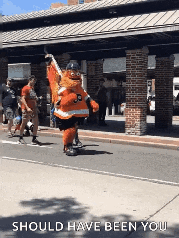 a mascot is walking down a street with the words should have been you written below him