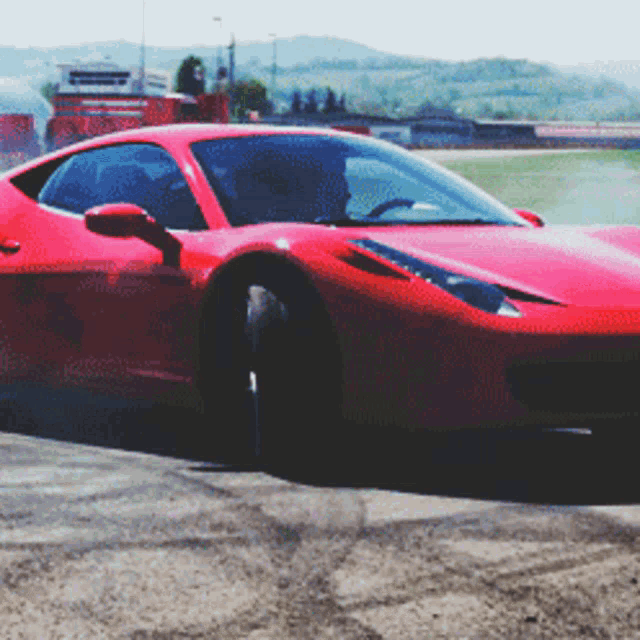 a red sports car is driving down a road