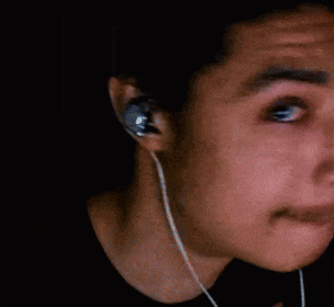 a close up of a man 's face with a beard and headphones