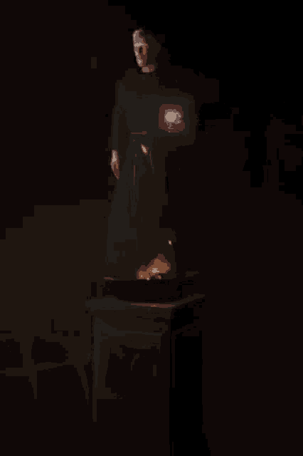 a statue of a man in a robe is standing on a pedestal with the letter d on it