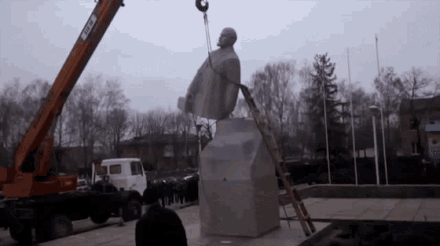 a statue is being lifted up by a crane that says ccc