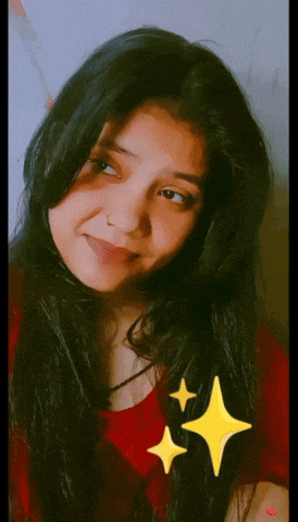 a girl in a red shirt is smiling with a yellow star in the background