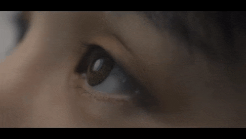 a close up of a woman 's eye looking at something in the dark .