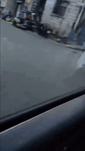 a car is driving down a street with a yellow sign on the side of it