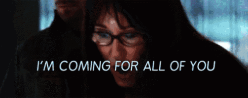 a woman with glasses says i 'm coming for all of you in a dark room