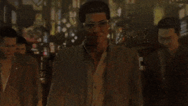 a group of men in suits and glasses are walking down a city street .