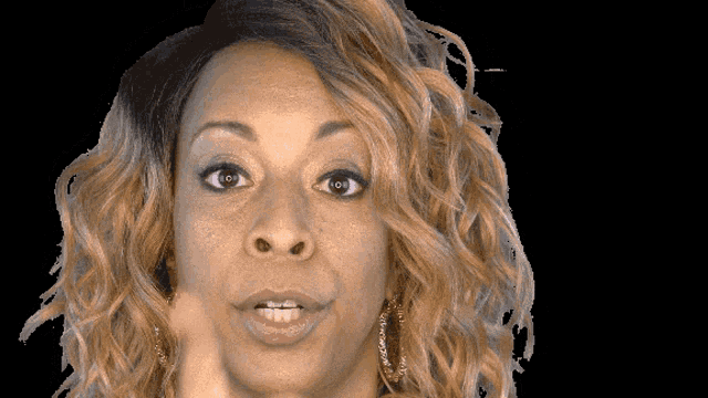 a close up of a woman 's face with her mouth open and a black background