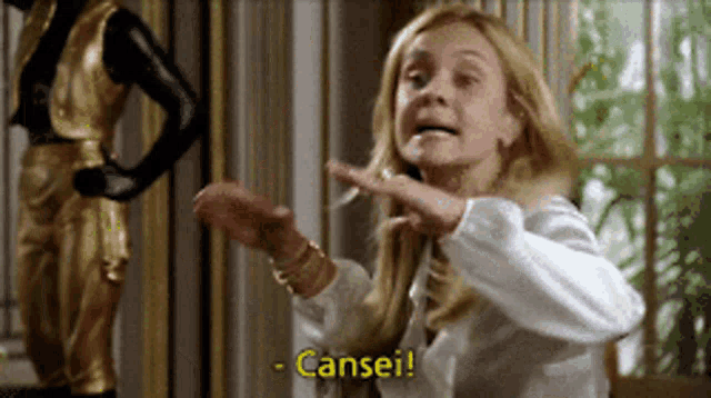 a woman in a white shirt is making a funny face and saying cansei