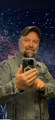 a man in a denim jacket is taking a picture of himself
