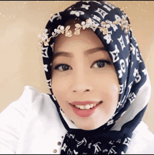 a woman wearing a louis vuitton scarf on her head smiles for the camera