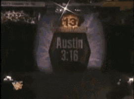 a wrestler is standing in a coffin wearing a black vest with a skull and crossbones on it .