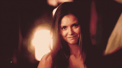 a woman with long brown hair is smiling and looking at the camera .
