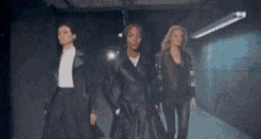 a group of women are standing next to each other in a dark hallway .