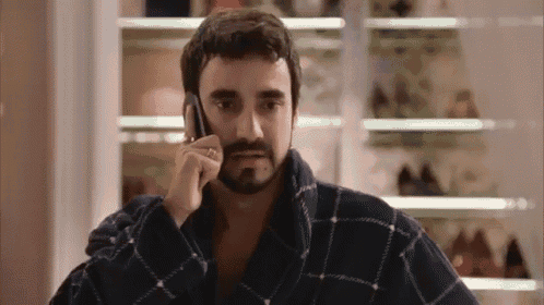 a man in a robe is talking on a cell phone .