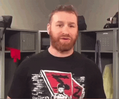 a man with a beard wearing a black t-shirt with a picture of a man on it .