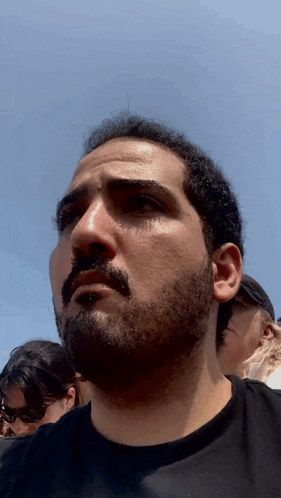 a man with a beard looks at the camera