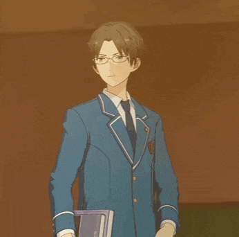 a man wearing glasses and a blue suit holds a book
