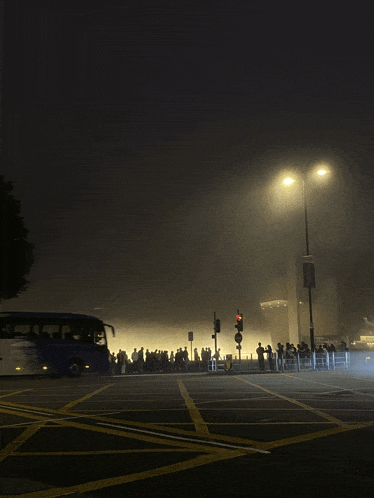 a blue bus is driving down a foggy street