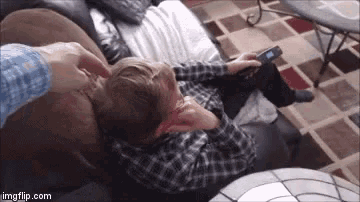 a boy laying on a couch with a remote control in his hand and the website imgflip.com at the bottom of the image