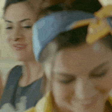 a woman with a blue headband on her head smiles