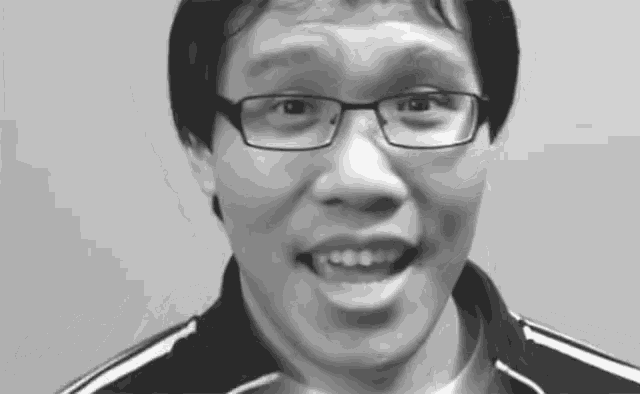 a black and white photo of a man wearing glasses making a funny face