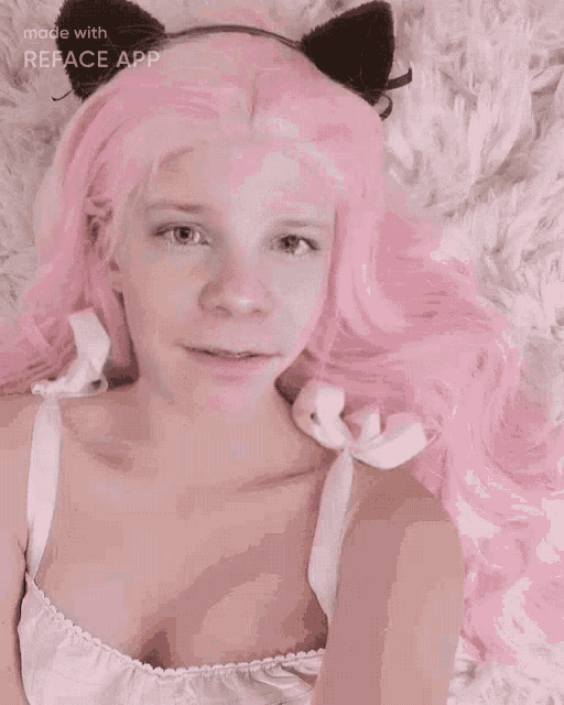 a girl with pink hair sticking her tongue out