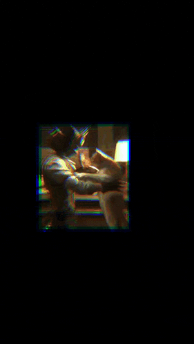 a man is holding a cat in his arms in a blurry picture .