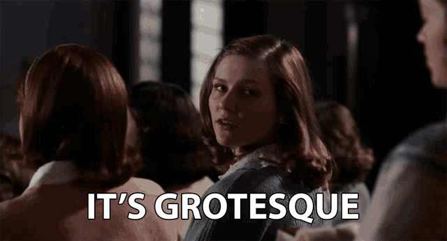 a woman stands in a crowd with the words " it 's grotesque " above her