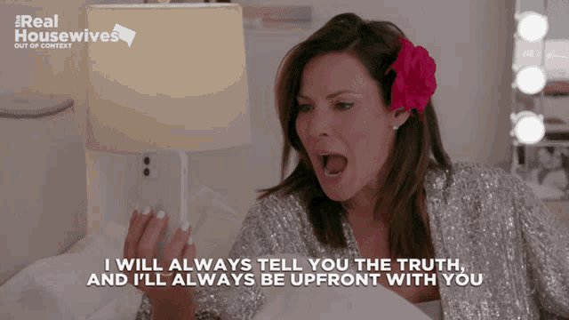 a woman with a flower in her hair looks at her phone and says i will always tell you