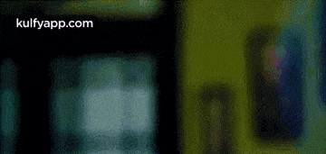 a close up of a man 's face in a dark room with a green background .