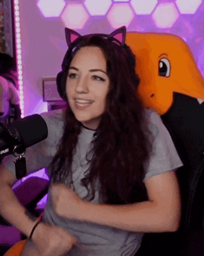 a woman wearing cat ears and headphones is sitting in a chair