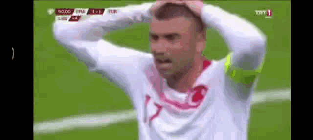 a soccer player is holding his head in his hands during a match .