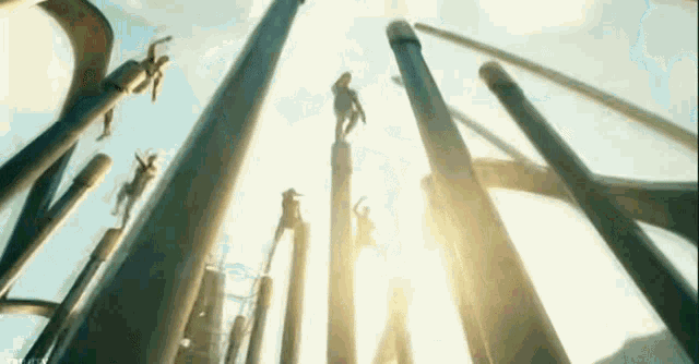 a group of people are standing on top of a bunch of columns .