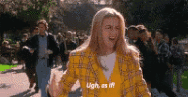 a woman in a yellow plaid jacket is standing in front of a crowd .