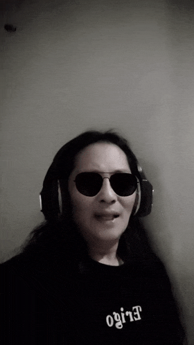 a woman wearing sunglasses and headphones has the word elife on her shirt