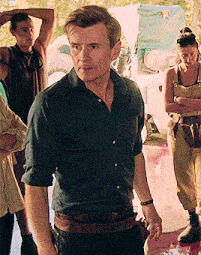 a man in a blue shirt is standing in a crowd of people