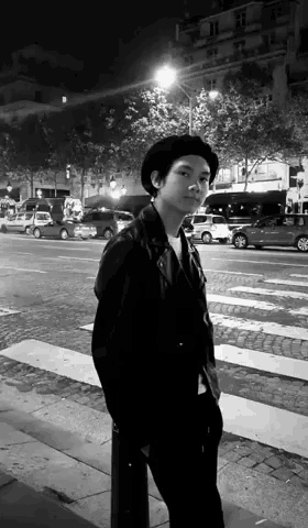 a black and white photo of a person standing on a street