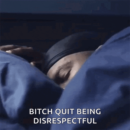 a man is laying in bed under a blue blanket with the words bitch quit being disrespectful written on it .