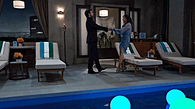a man and woman are dancing near a pool