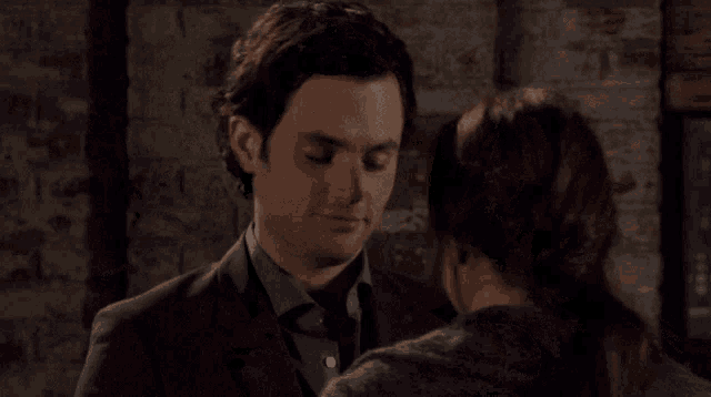 a man and a woman are hugging with their eyes closed
