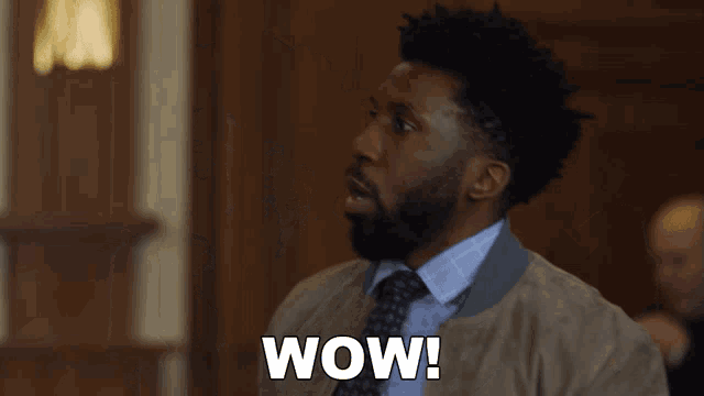 a man in a suit and tie says wow in a courtroom