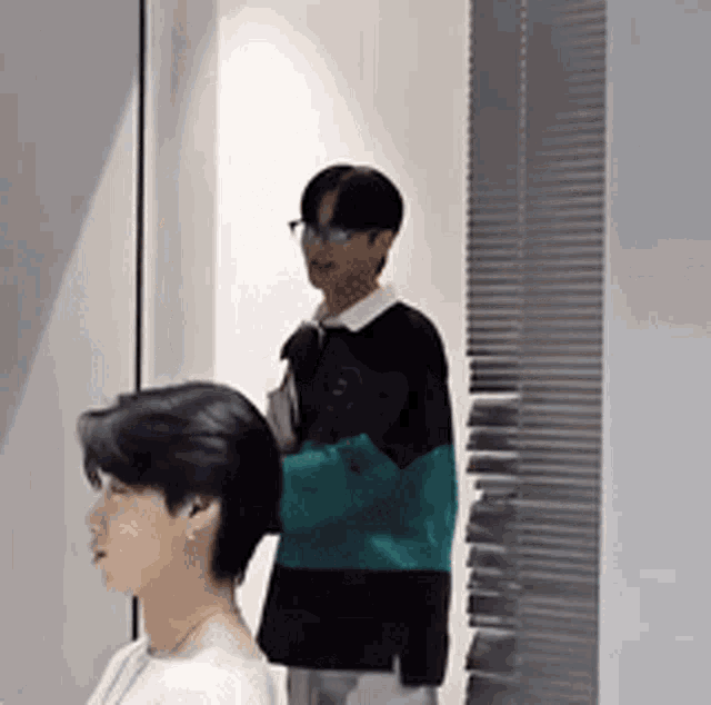 two men are standing next to each other in a room