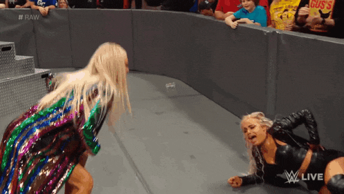 two women are wrestling in a ring with the words raw written on the wall