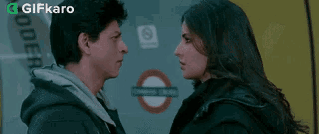 a man and a woman are looking at each other in front of a building .