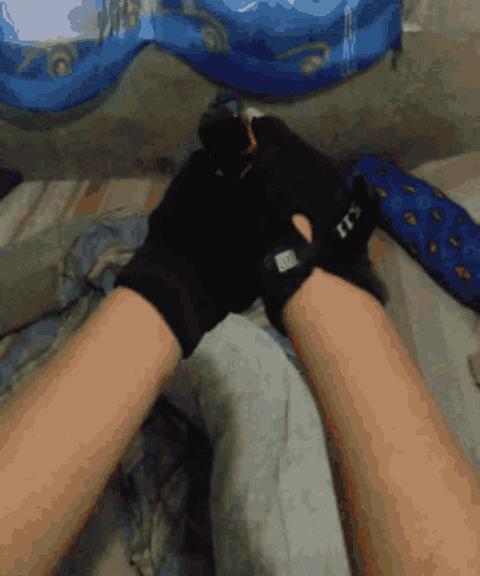 a person wearing a pair of black gloves that say it 's on it