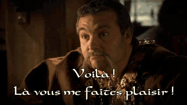 a man with a long mustache says voila in a foreign language