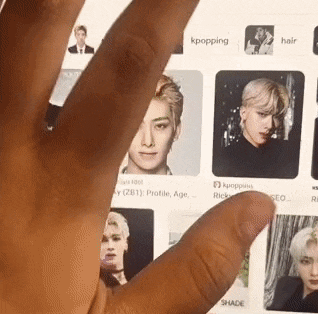 a close up of a person 's hand holding a tablet with a bunch of pictures on it .