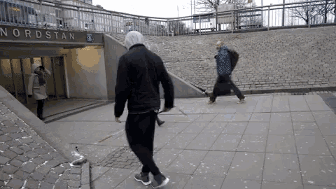 a man in a hooded jacket walks towards a nordstan exit