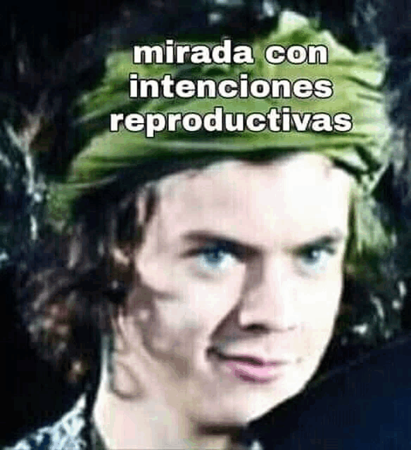 a close up of a man wearing a green turban with the words mirada con intenciones reproductivas written on it .